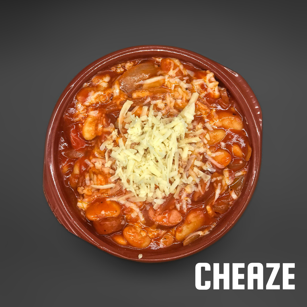 Maple BBQ baked beans topped with grated vintage Cheddar in a terracotta dish