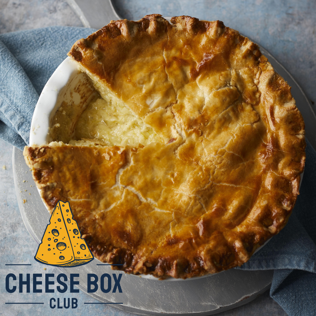 Golden cheese and onion pie with crimped pastry and a slice cut out to show the filling, with the Cheese Box Club logo