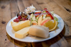 Cheese Loft Café lunch plate of cheese wedges, a bread roll, salad, grapes, orange and chutney