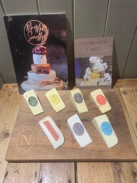 Cheese Wedding Cake Sample Pack: Nettle, Original, Oak Smoked, Chilli, Chesterwood, Elsdon and Redesdale wedges on a wooden board