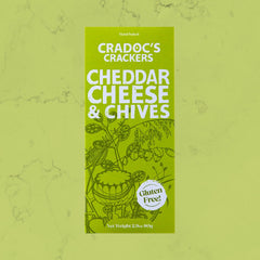 Green 80g box of Cradoc's Gluten Free Cheddar & Chives Crackers on a matching green marble background