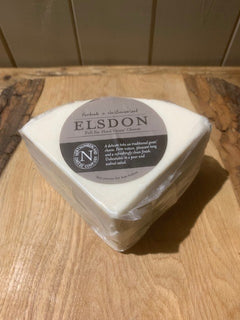 Triangular wedge of Elsdon Goats Cheese wrapped in clear film with its grey label, on a rustic wooden board