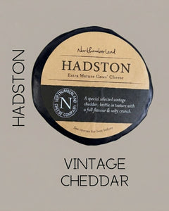 Black-waxed Hadston truckle on a grey background, captioned Hadston Vintage Cheddar