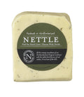 Nettle Cheese wedge flecked with green nettles in its dark green Northumberland Cheese Company label