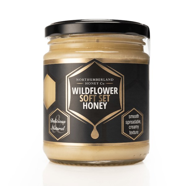 Northumberland Honey Co Wildflower Soft Set Honey, creamy set honey in a jar with a black and gold hexagon label
